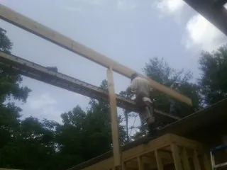 Carpenter setting a ridge beam over a new addition frame — Ice Dam Removal by Roofing Brothers in Ellenburg Center