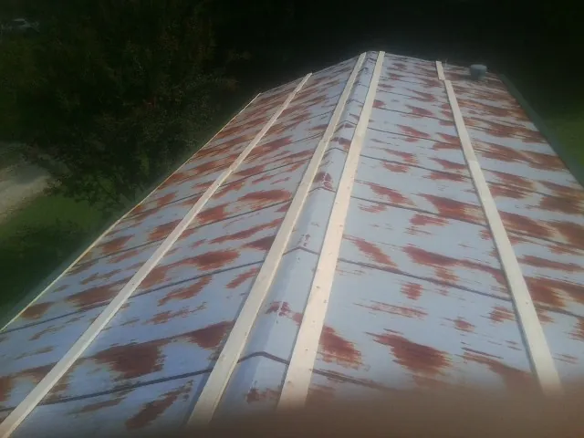 Rusted metal roof panels with new wood purlins before replacement — Storm Damage Roof Repair in Ellenburg Center by Roofing Brothers