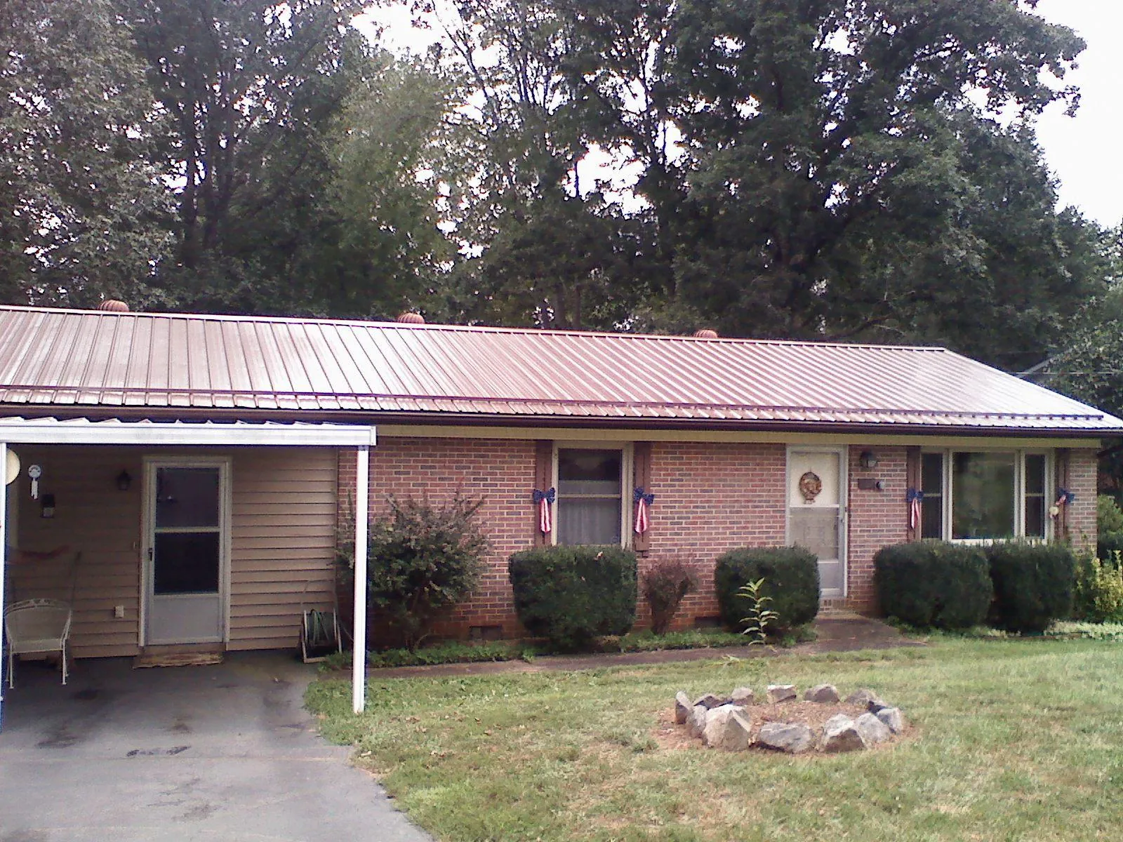 Bronze metal roof and carport on a brick ranch home — Roof Repair work by our crew in Ellenburg Center