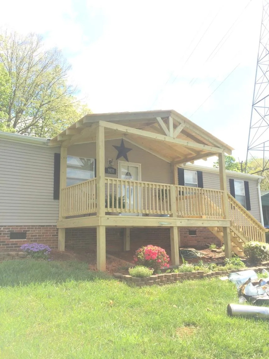 New gabled porch roof and deck railing added to a ranch home in Ellenburg Center